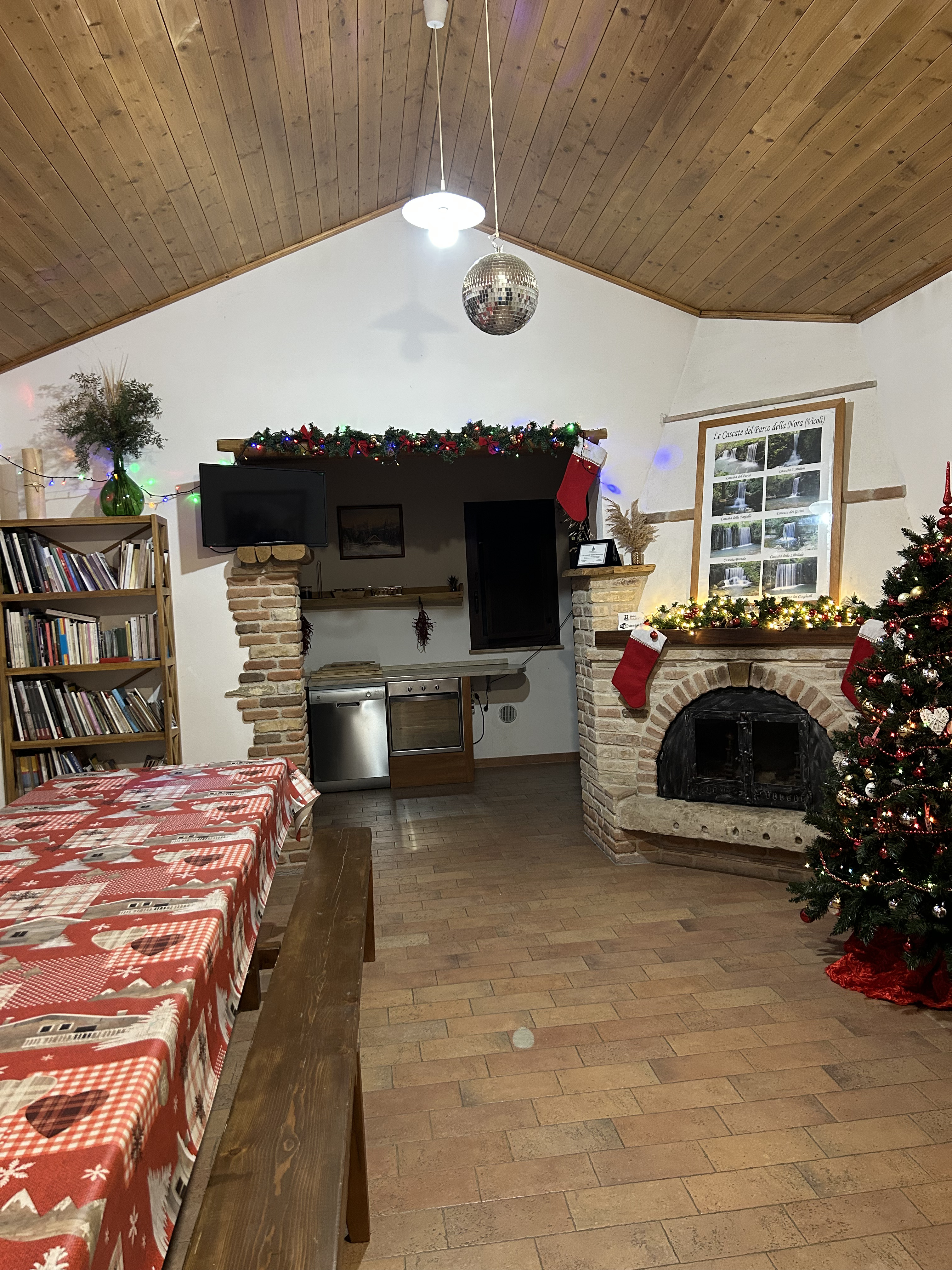 Salone comune con grande camino in pietra, cucina e tavolo da pranzo del Mulino Brandolini