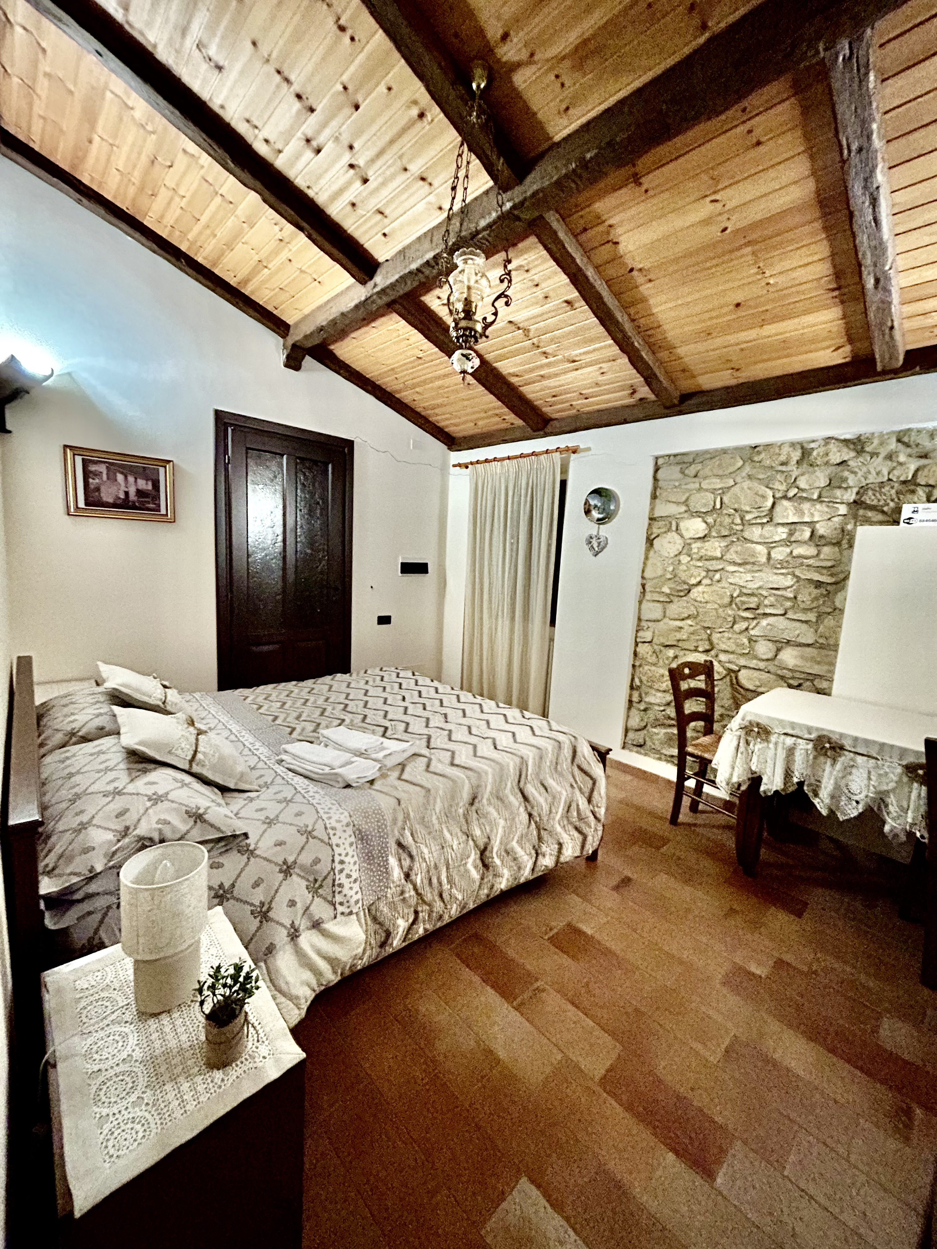 Dettaglio camera 2 — pietra a vista e arredi rustici