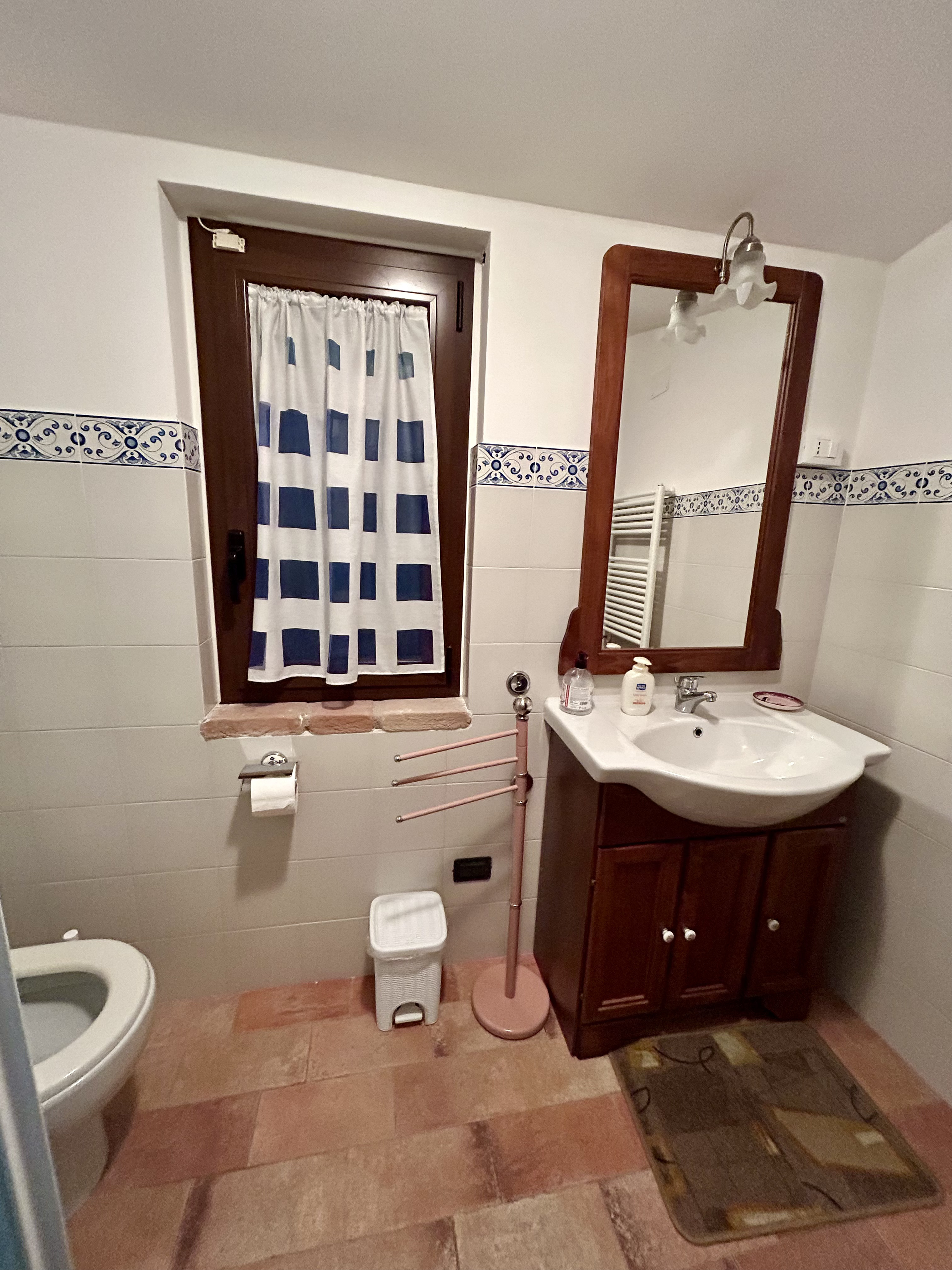 Dettaglio camera 5 — letto e finestra sul parco fluviale